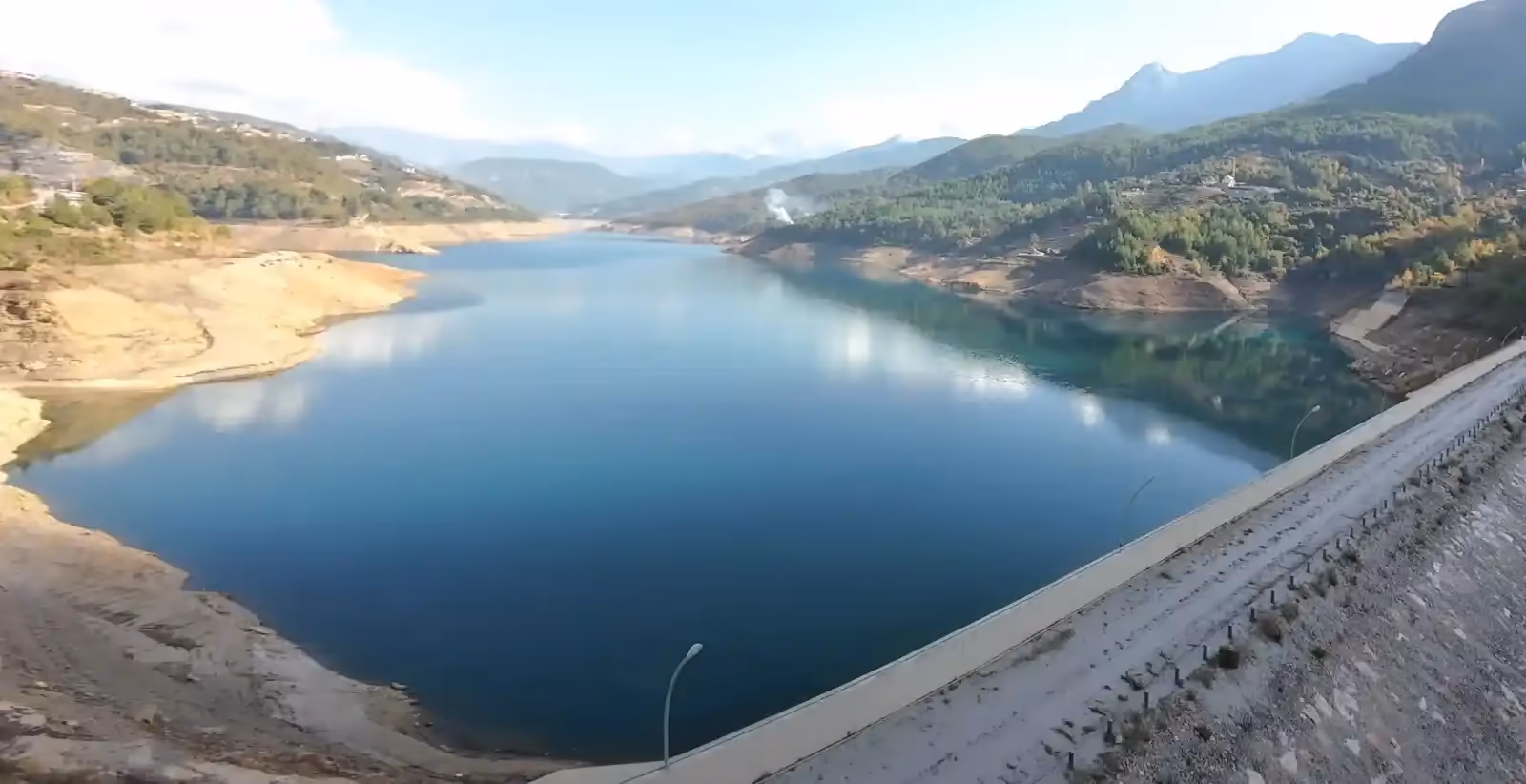 An incredibly beautiful reservoir (lake) surrounded by lush green forests and tall, stunning